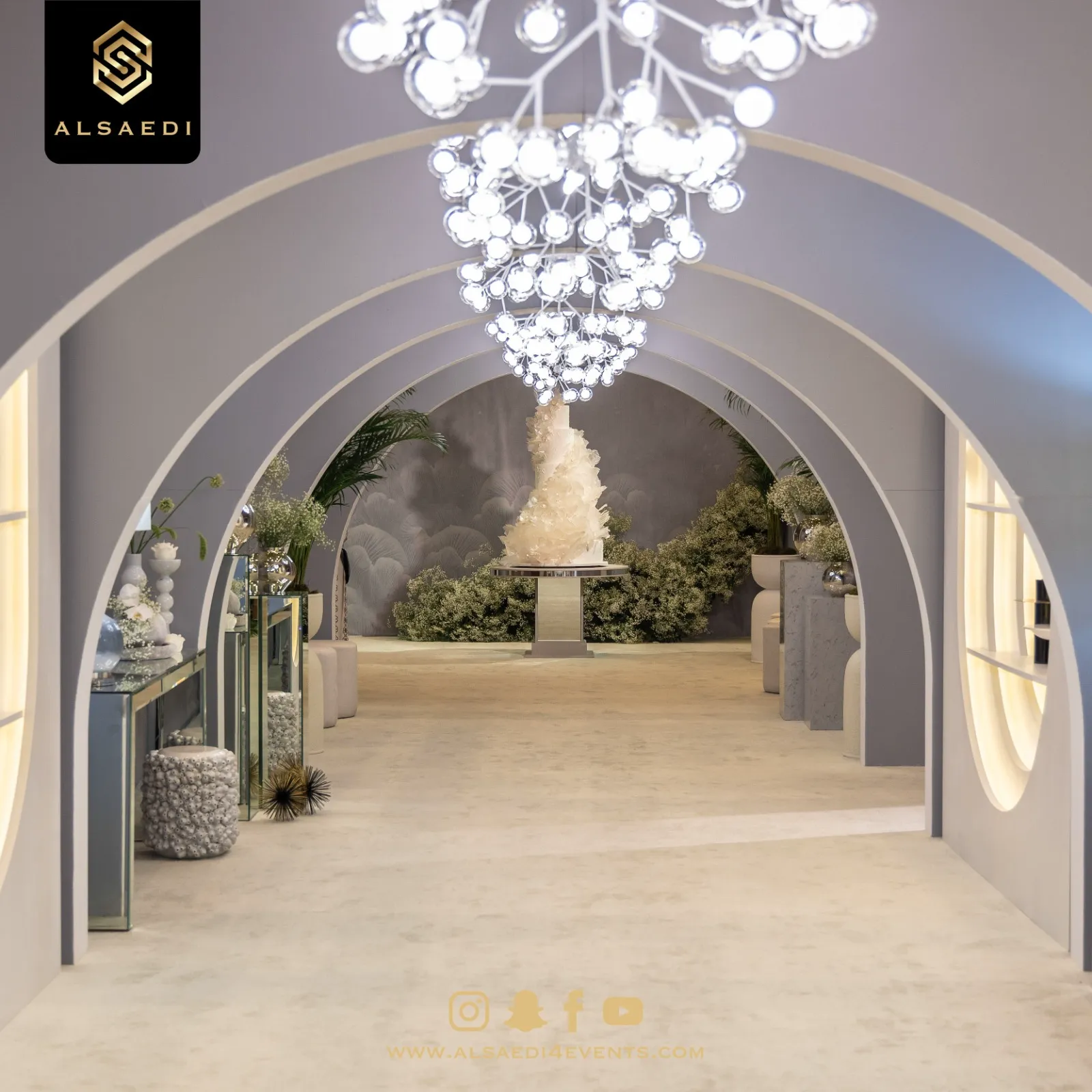 Arched bridal entrance with chandelier and cake