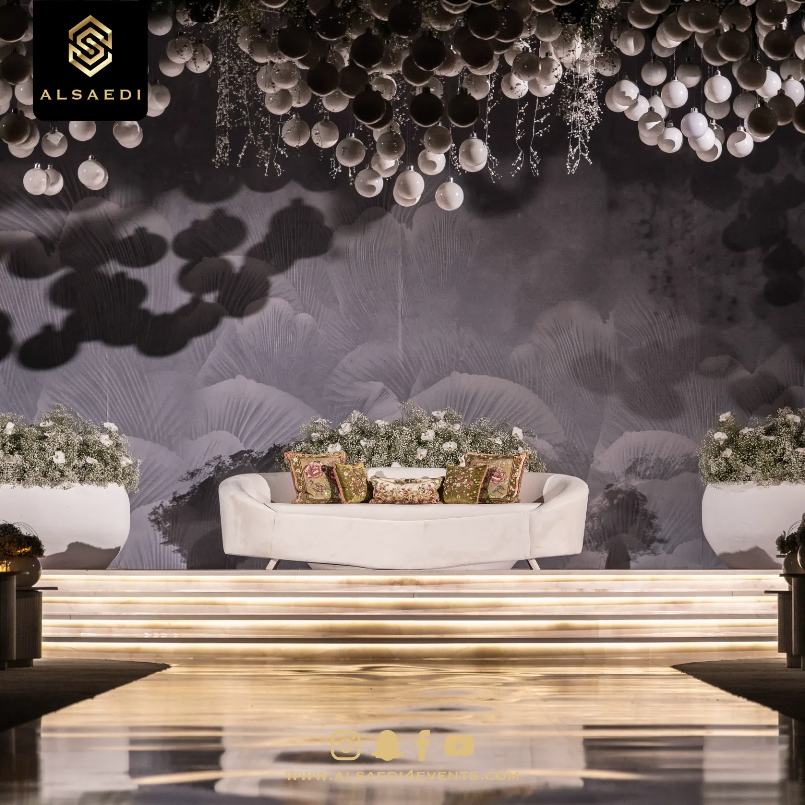 Illuminated kosha stage framed by white florals