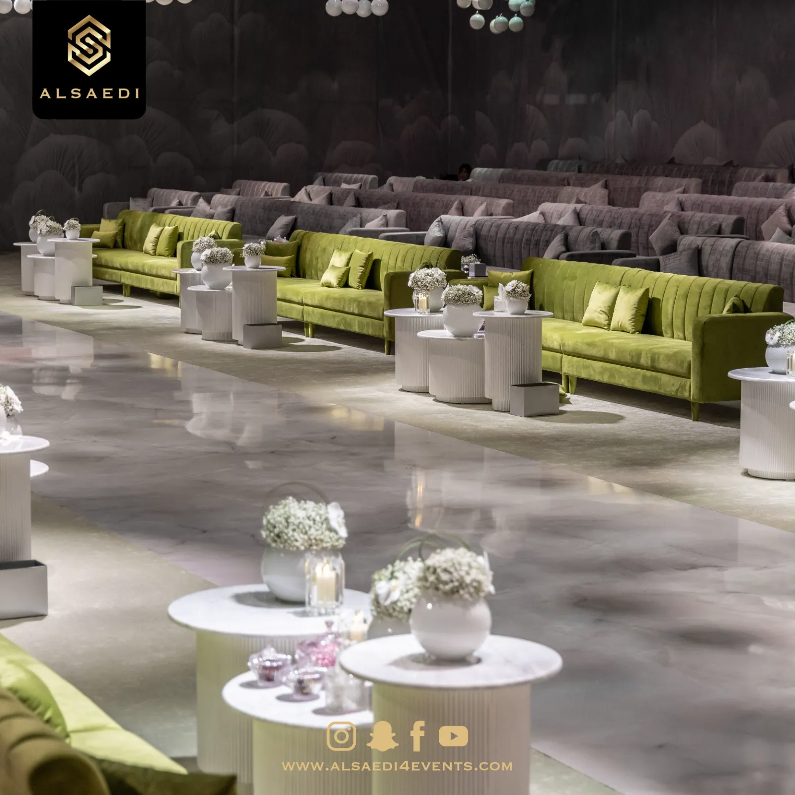 Green velvet lounge seating with floral centrepieces